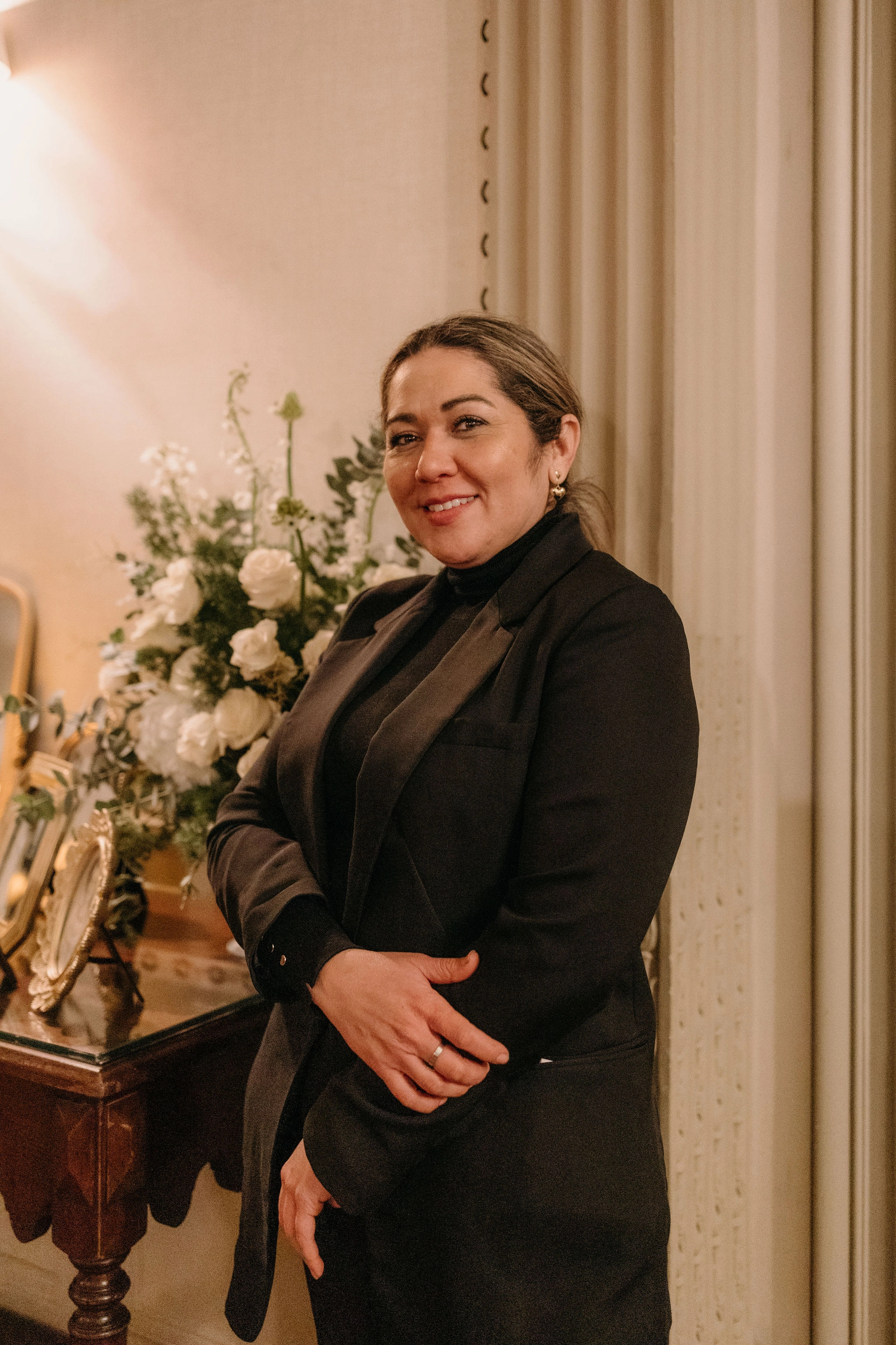Retrato de medio cuerpo de Sara Laínez en un entorno de evento elegante.